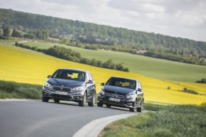 Match BMW Série 2 Active Tourer 2015 et Mercedes Classe B roulant sur une route près d'un champ de colza