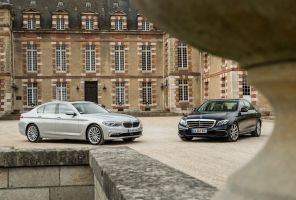 bmw serie 5 et mercedes classe e près d'un mur