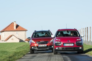 Citroën C4 Cactus Jelly Red Shine Edition 2016 et Peugeot 2008 Crossway orange roulant sur une route de campagne vue avant