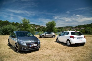trois Peugeot 208 garées dans un champ