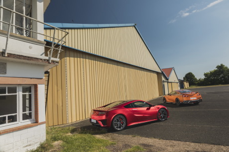 Honda NSX rouge vs Nissan GT-R orange vue arrière hangar
