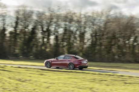 Alfa Romeo Giulia Quadrifoglio 2017 rouge sur une route vue arrière gauche