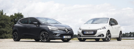 Renault Clio 2016 grise garée à côté d'une Peugeot 208 GT Line blanche vue avant