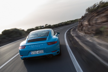 Porsche 911 2016 Carrera S type 991 restylée bleu miami roulant dans un virage à droite vue arrière