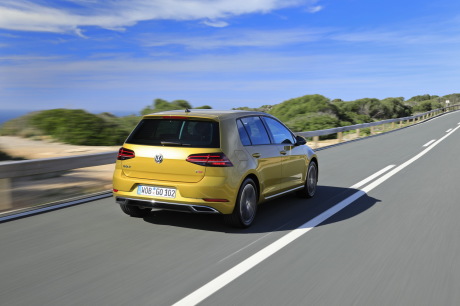VW Golf 2017 restylée jaune roulant le long de la mer arrière droit