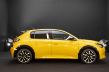Peugeot 208 (2019) vue de profil jaune Faro en studio sur fond noir