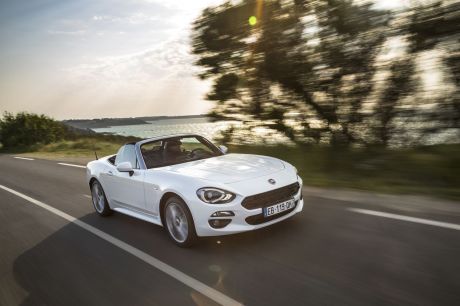 Fiat 124 Spider 2016 blanc roulant sur une route décapoté vue avant