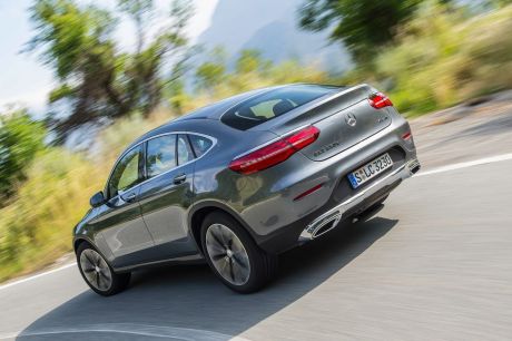 Mercedes GLC coupé 2016 gris dans un virage vue arrière gauche