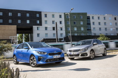 Kia Ceed bleue et Peugeot 308 grise statique avant en ville