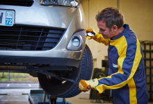 Un homme controle les pneus d'une voiture