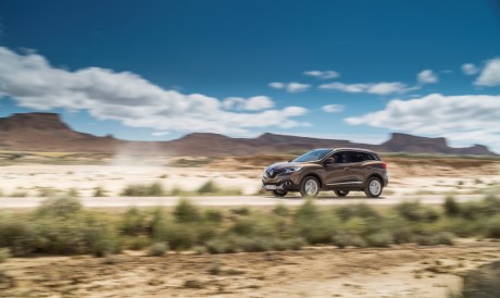 Renault Kadjar 2015 4x4 marron roulant sur un chemin de terre