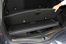 Le cache-bagages prend place sous le plancher de coffre quand celui-ci est en position haute.